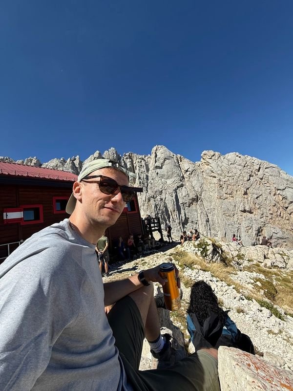 Giulio sitting outside the Rifugio Franchetti mountain hut, among the rock walls of the Gran Sasso