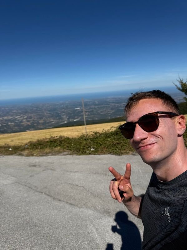 Giulio in sunglasses on the Blockhaus, with the plain stretching to the sea behind him
